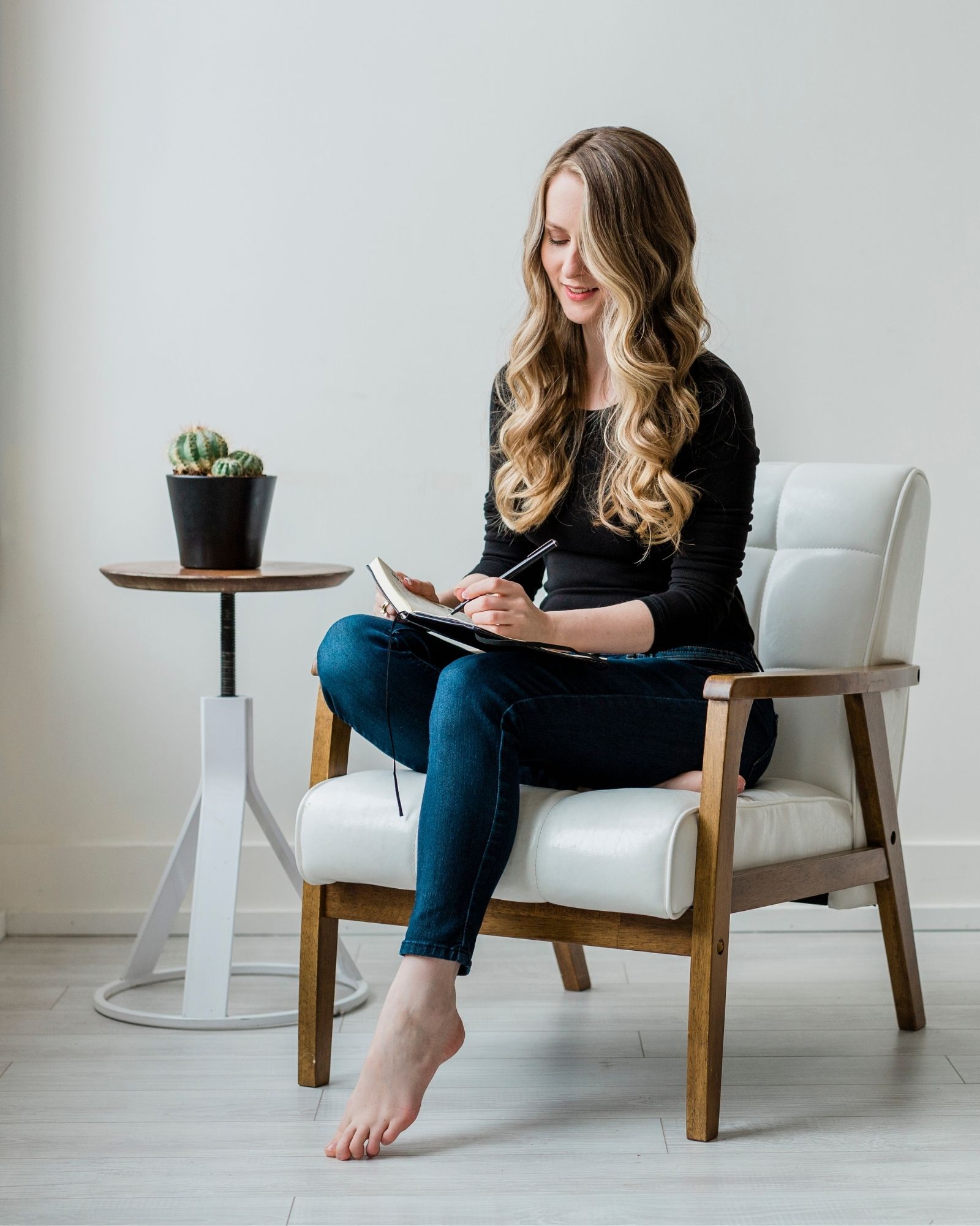 Gillian Perkins sitting on a chair writing notes